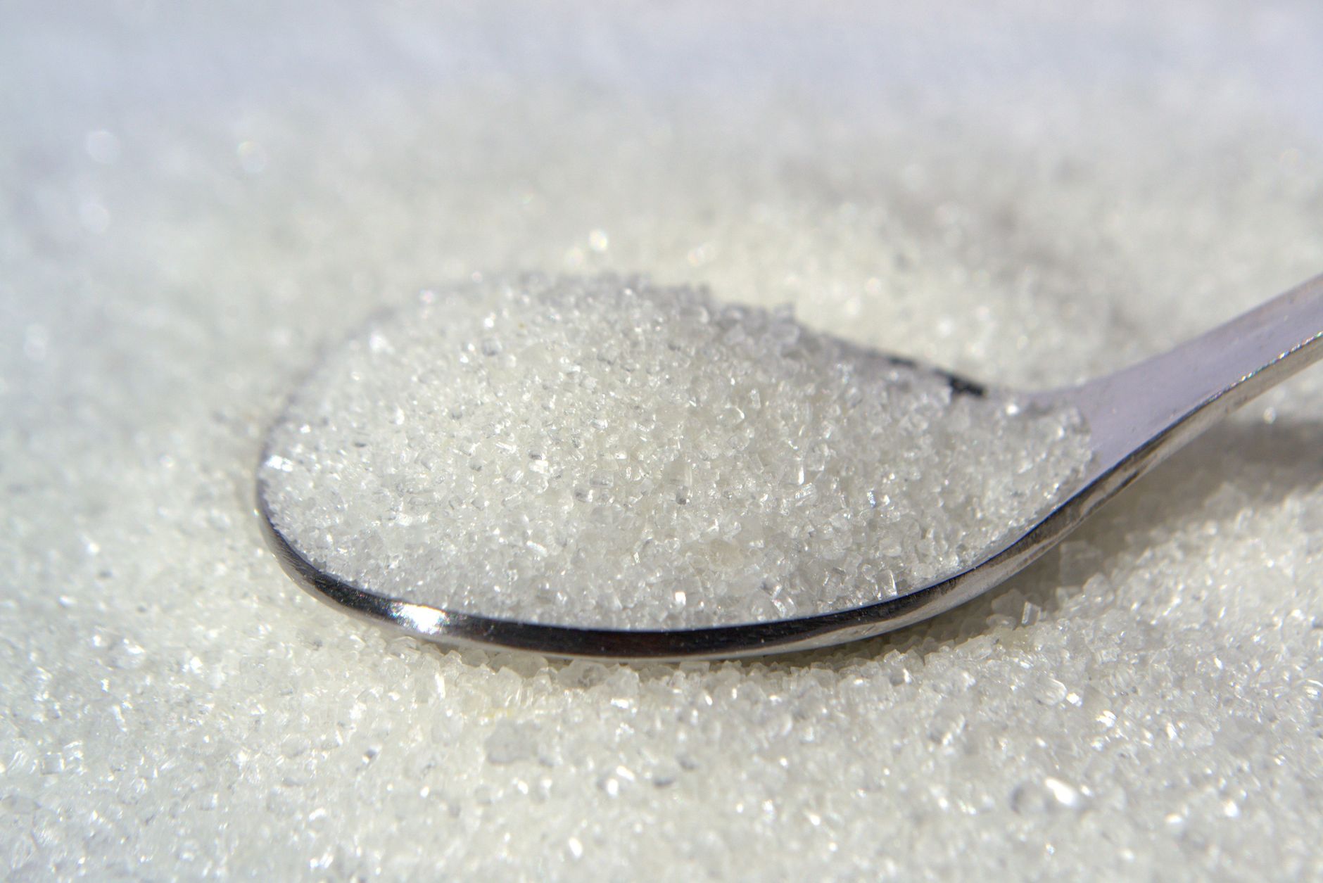 Powdered sweetener raw material on a spoon (illustration)