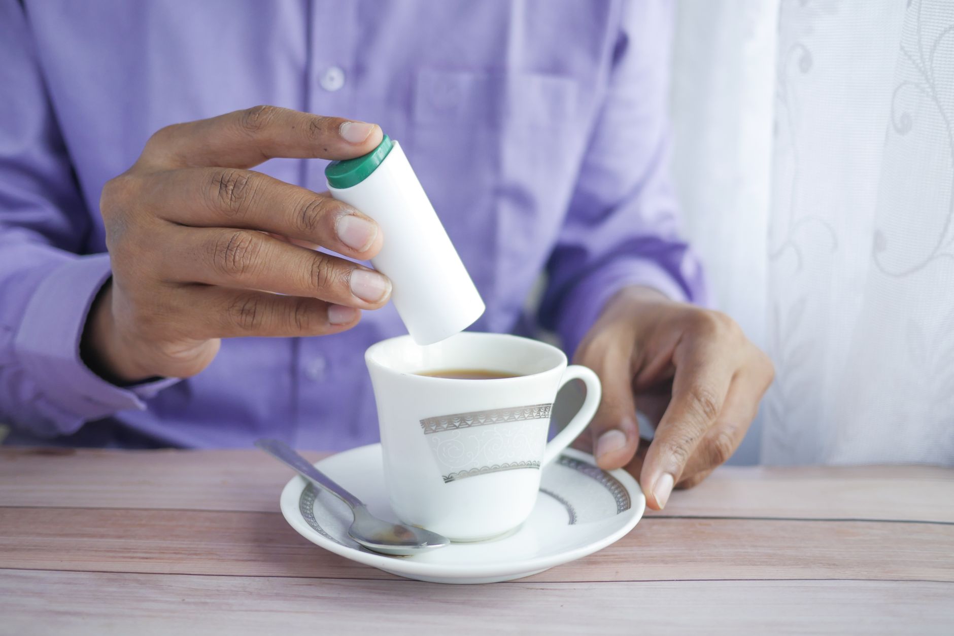 Adding sweetener to tea (illustration)